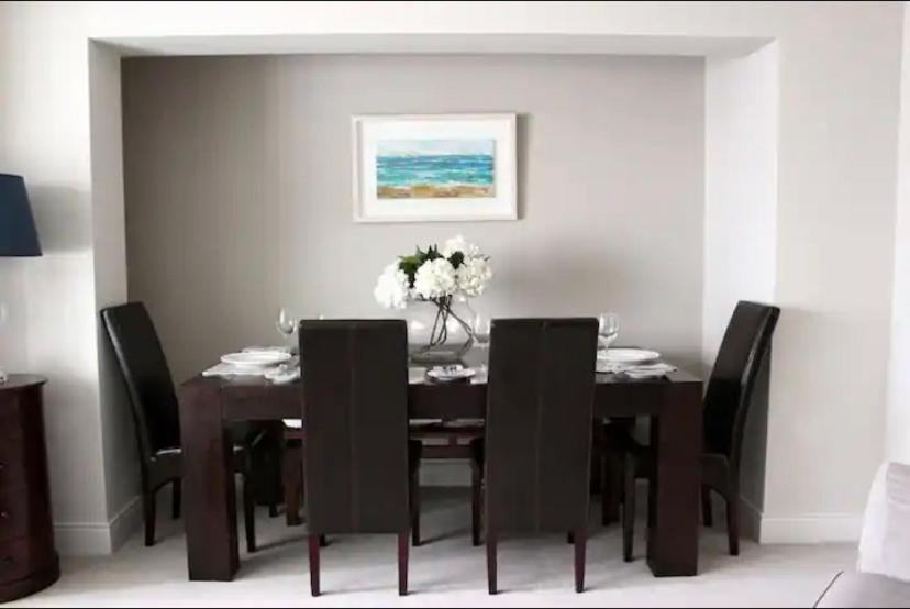a dining room with a table with black chairs at MacKenzie Lodge in Lahinch