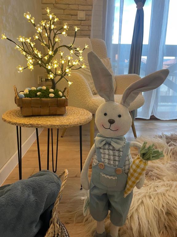 a stuffed rabbit standing next to a table with a pineapple at Boutique apartment Bansko Bell Tower in Bansko