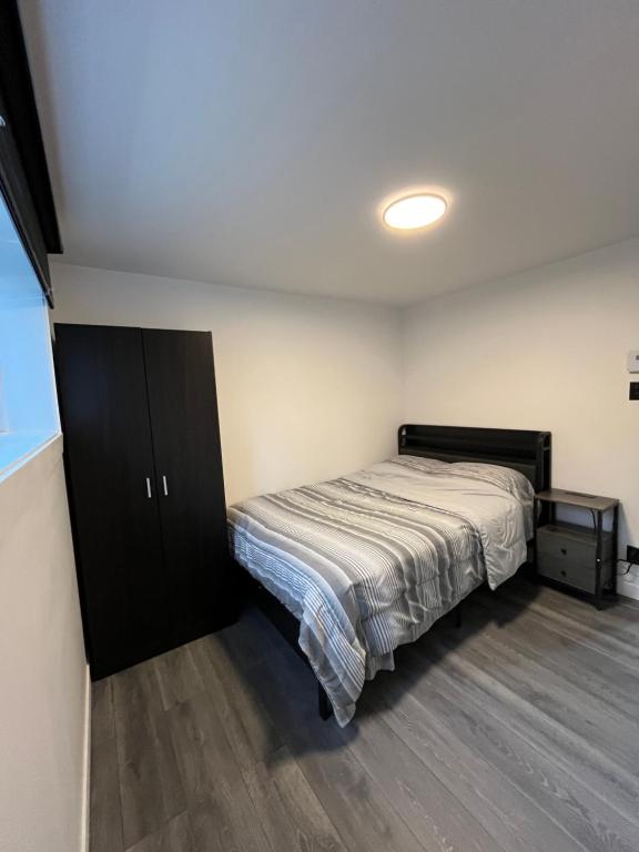 a bedroom with a bed and a cabinet in it at Luxueuse Villa, Unique en ville in Drummondville