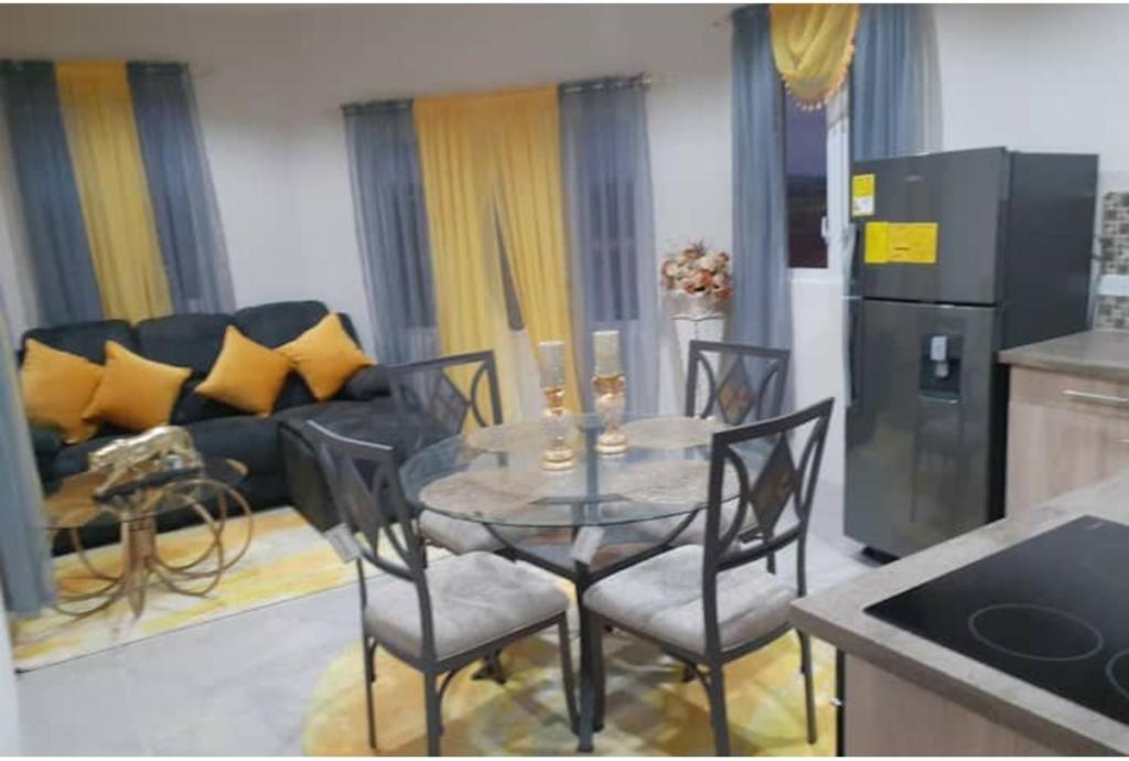 uma cozinha e sala de estar com mesa e cadeiras em Fabulous Apartments Barbados em Christ Church