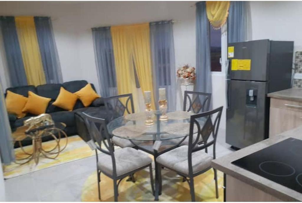 a kitchen and living room with a table and chairs at Fabulous Apartments Barbados in Christ Church