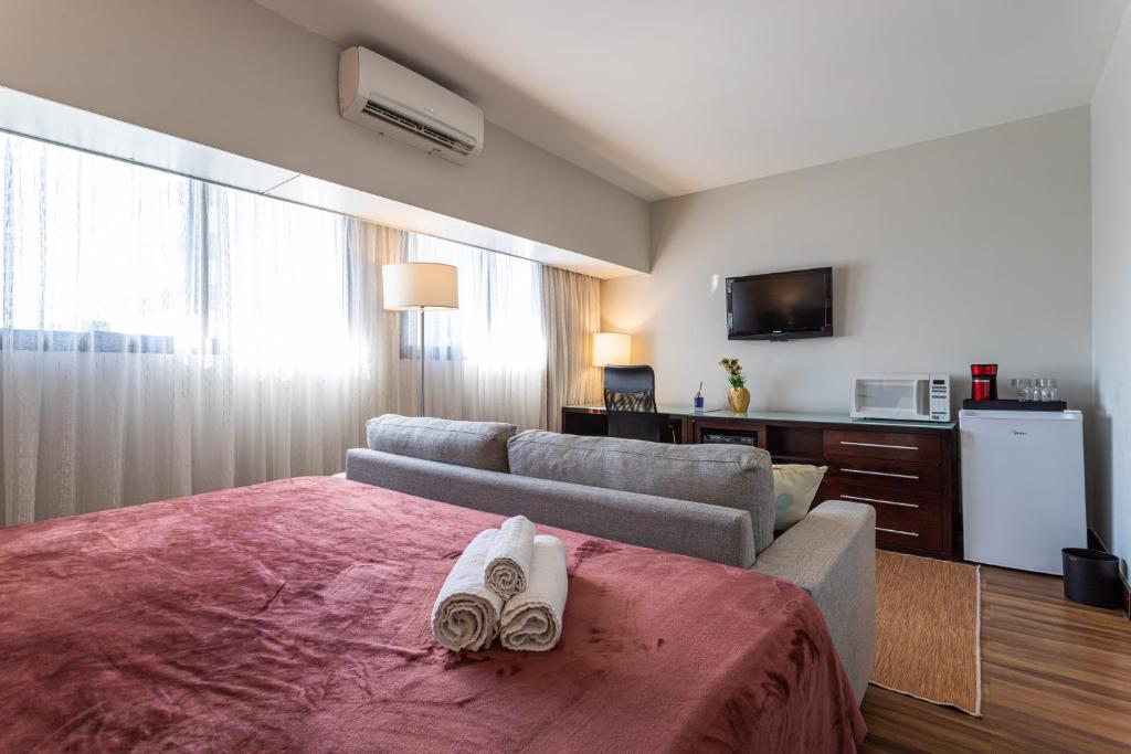pokój hotelowy z łóżkiem i kanapą w obiekcie Maximus Luxury in Wyn Berrini - WTC w São Paulo
