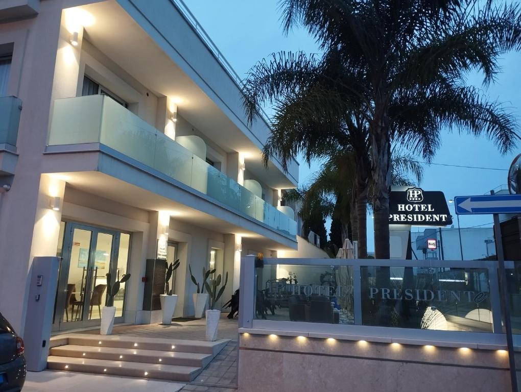 a building with a sign in front of it at Hotel Presidente in Porto Cesareo