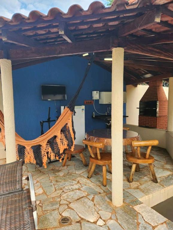a patio with a hammock and a table and chairs at Hotel Pousada Casa da Terezinha in Frutal