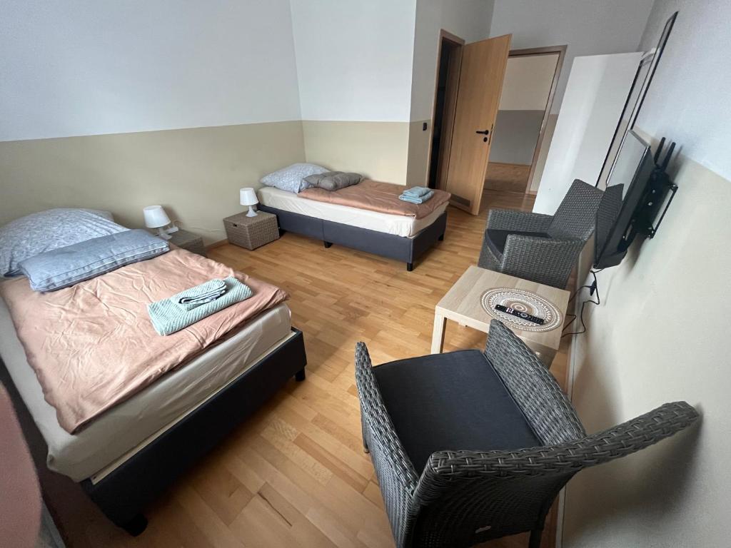 a room with two beds and a chair and a television at Doppelzimmer mit TV in Meine