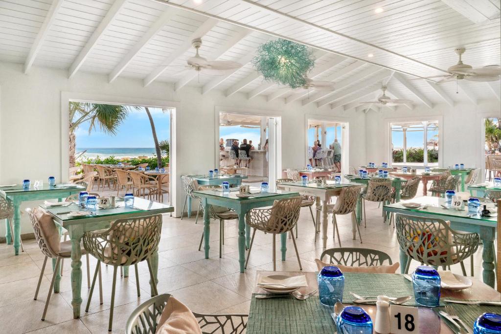 a dining room with tables and chairs and the ocean at Sugar Bay Barbados - All Inclusive in Bridgetown
