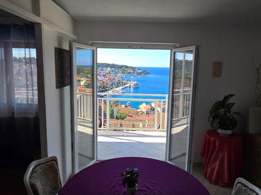 um quarto com uma mesa roxa e vista para o oceano em Apartments Boćin Rosso em Hvar