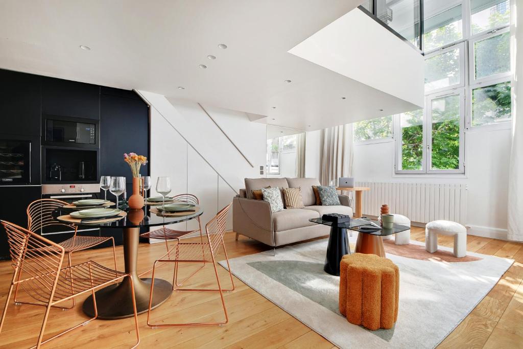un salon avec une table et des chaises dans l'établissement Amazing Loft 2BR - Eiffel Tower, à Paris