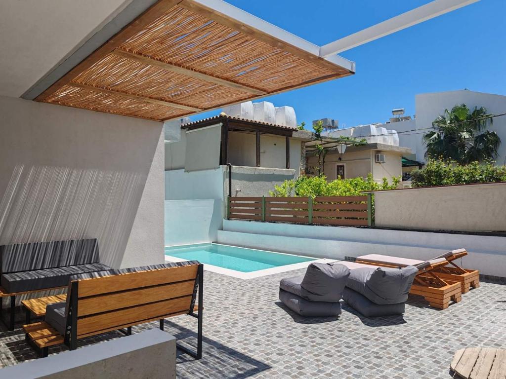 a patio with a bench and a swimming pool at Amphitrite Beach House in Agios Nikolaos