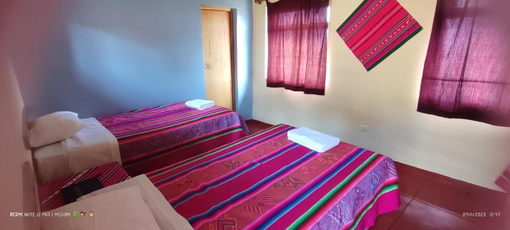 普諾的住宿－TITICACA'S SALA UTA，一间卧室配有一张带彩色毯子的床