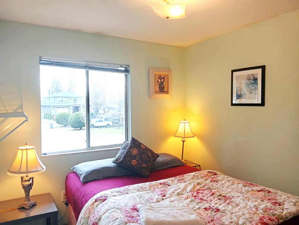 a bedroom with a bed with two lamps and a window at Stylish & Charming Holiday Home - Great Location C3 in Surrey