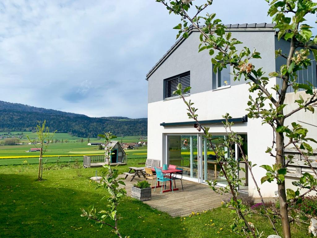 Casa con terraza con mesa y sillas en Spacieuse maison avec jardin, en Savagnier