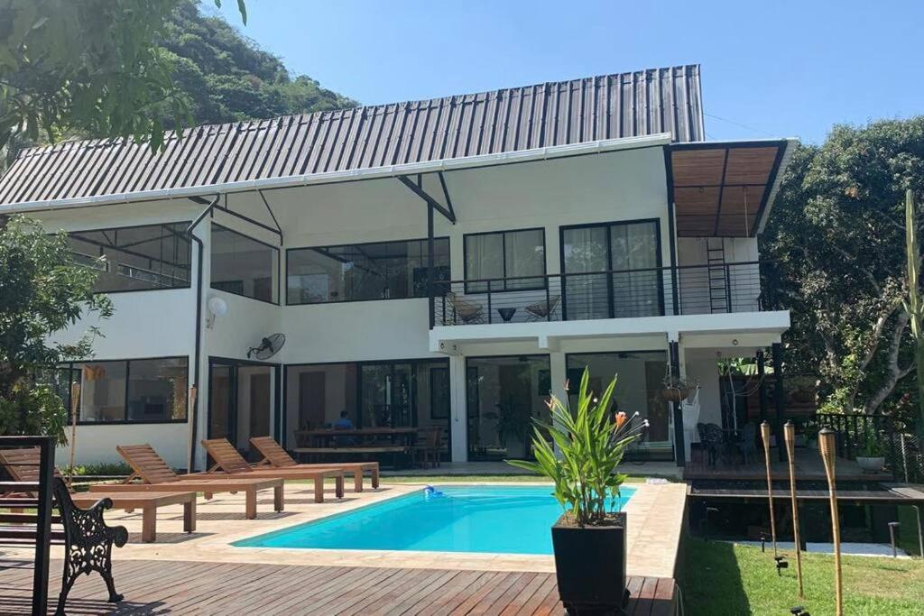 a large house with a swimming pool in front of it at Casa junto al río en Bolombolo in Concordia
