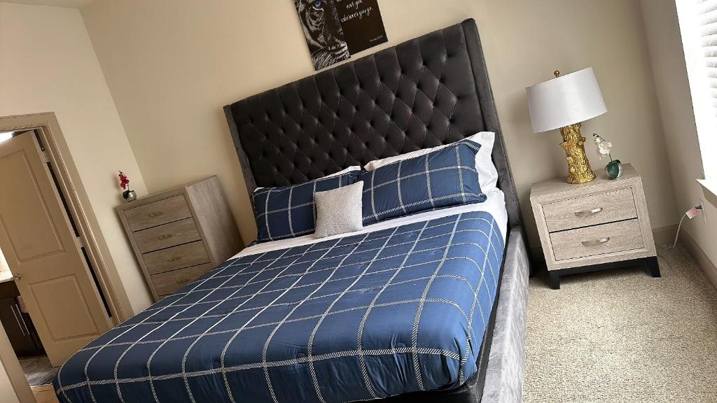 a bedroom with a blue bed with a black headboard at Domain at Kirby in Houston