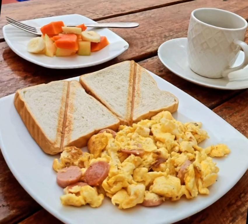 a plate of eggs and toast and a cup of coffee at Hotel Coco Beach Santa Marta in Santa Marta