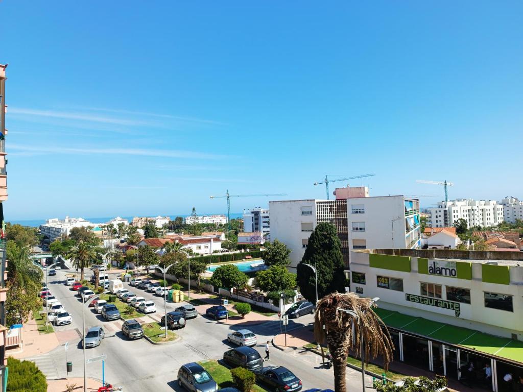 a city with cars parked in a parking lot at RIV - Reformado, Terraza con vistas al mar, 1 dormitorio, 800 metros de la Playa in Torremolinos