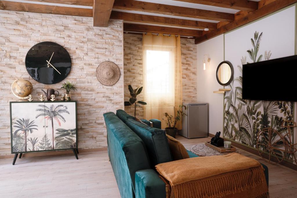 uma sala de estar com um sofá verde e uma parede de tijolos em Appart hôtel le 8 La Suite & Spa em Mâcon