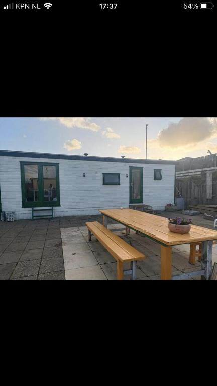 a wooden picnic table in front of a building at Beach house in Zandvoort