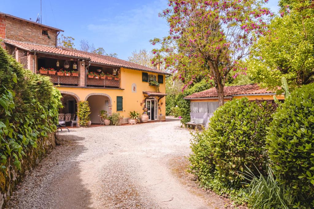 uma casa amarela com uma varanda e uma entrada em Il Cerretello - Tuscan Experience em Lucignano
