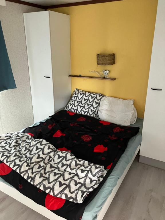 Una cama con un edredón blanco y negro. en Beach house, en Zandvoort