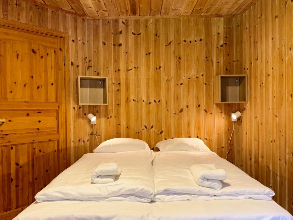 a bedroom with two beds and wooden walls at Flåm holiday home - mountain view - 1 km from Flåm in Flåm