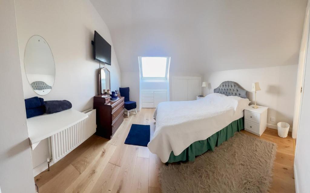 - une chambre avec un lit, un miroir et un canapé dans l'établissement DOONEEN HOUSE, à Killarney