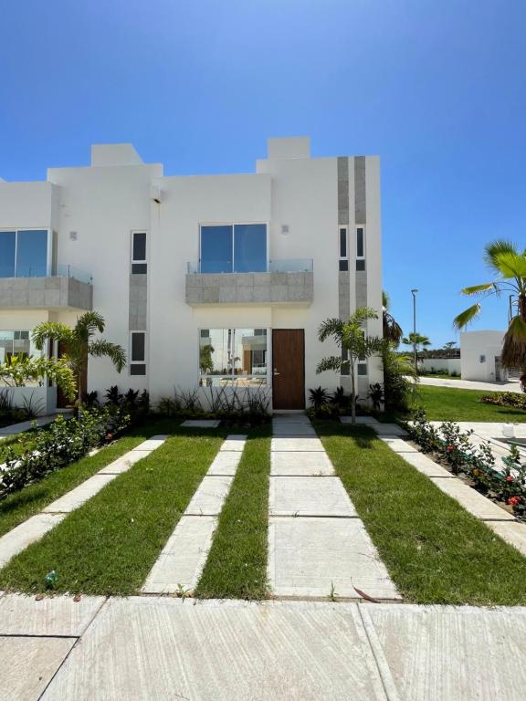 a large white building with a grass yard at Casa ISLA RODAS Altavela II in Los Algodones