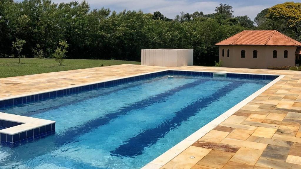 una piscina en un patio con una casa en Sítio São Luiz, R2: Refúgio rústico na Natureza en Quadra