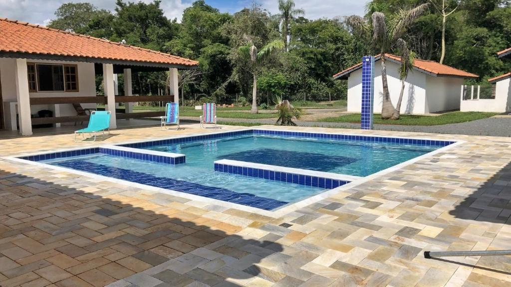 a swimming pool in a yard next to a house at Casa de Campo com Piscina e Churrasqueira in Quadra