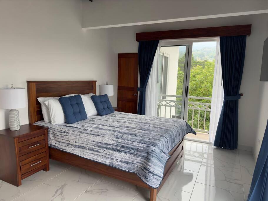 1 dormitorio con cama y ventana grande en Hermosa casa entre las Montañas- piso 2 en Birrí