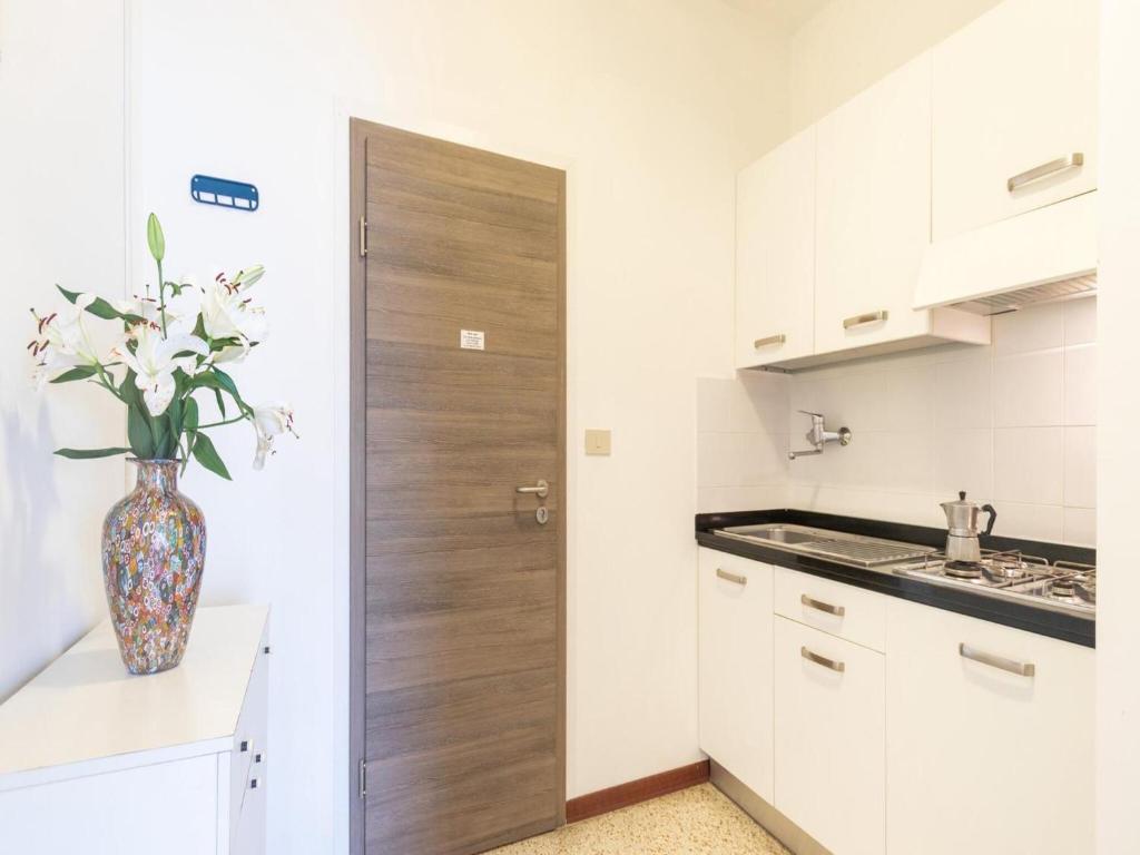 une cuisine avec un vase et des fleurs. dans l'établissement Cozy studio apartment with sea view - Beahost, à Lignano Sabbiadoro