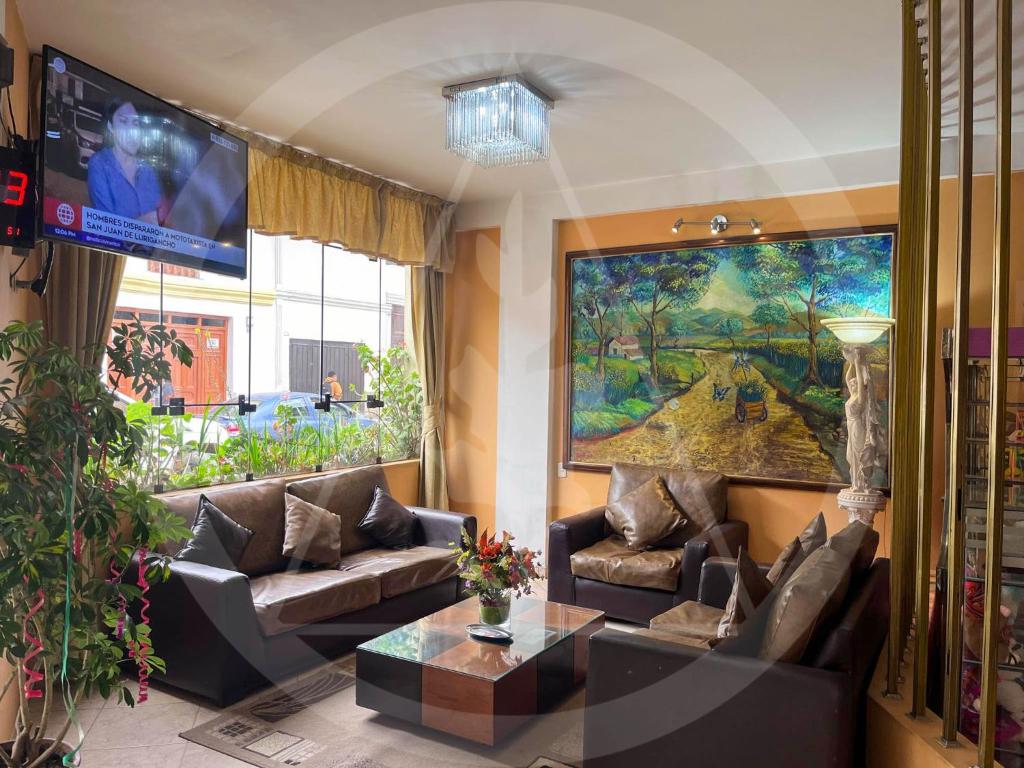 a living room with couches and a large painting at Retamas Hotel EIRL in Cajamarca