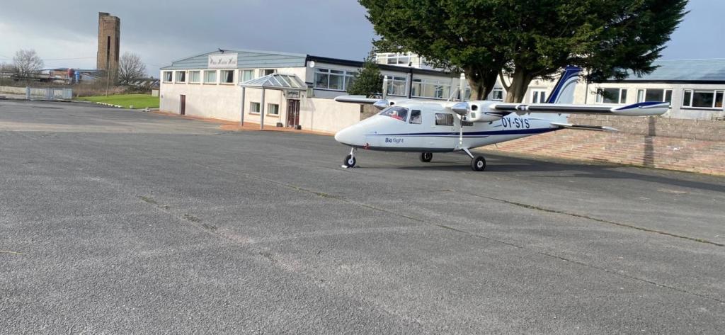 un pequeño avión está estacionado en una pista en The White Heather Hotel, en Wigton