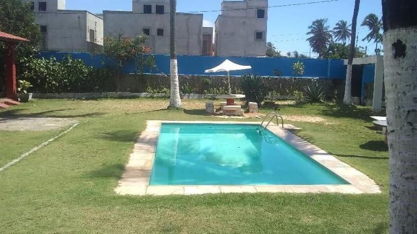 a small blue swimming pool in a yard at Casa de praia Vera in Caucaia
