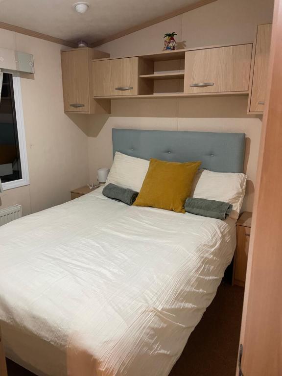 een slaapkamer met een groot bed met een blauw hoofdeinde bij Rockley Park- Turlin Valley 36 in Lytchett Minster