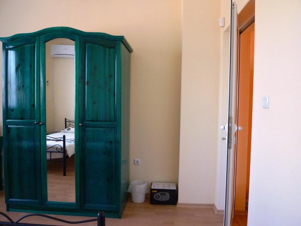 a green wooden cabinet in a room with a mirror at Sunny Villa in Dobrich