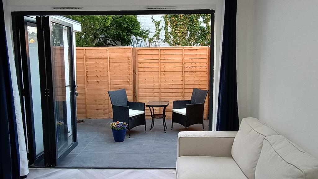 un soggiorno con divano e sedie su un patio di London Studios and Suites a Harrow