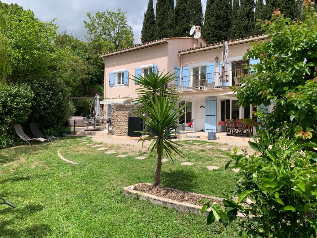 una pequeña palmera frente a una casa en LUVA d'Azur, Rez de villa LE RIOU - LE VALLON, en Le Bar-sur-Loup