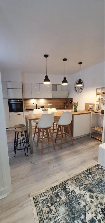 une cuisine et une salle à manger avec une table et des chaises dans l'établissement Maison Cosy à Vichy, à Vichy