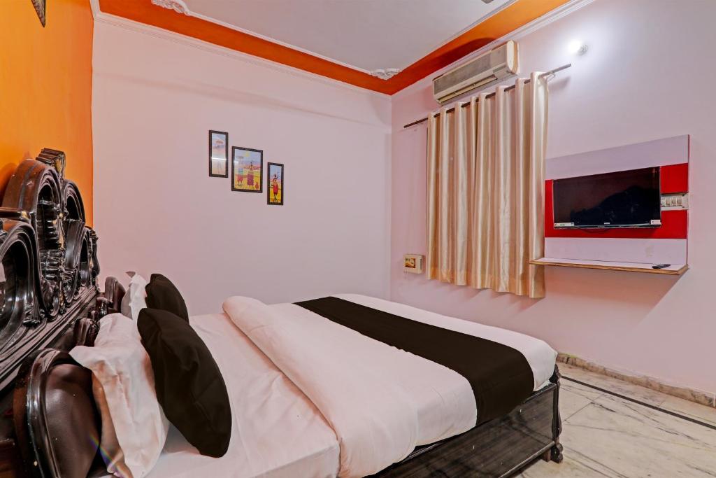 a bedroom with a bed and a tv in it at OYO Flagship Drip Stay Inn in Lucknow