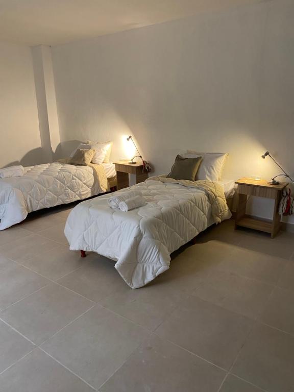 um quarto com duas camas e duas mesas de cabeceira em GMP suites em San Miguel de Tucumán
