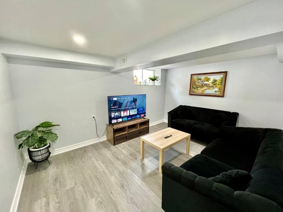 a living room with a couch and a tv at Basement Unit 25-Minute Downtown in Toronto