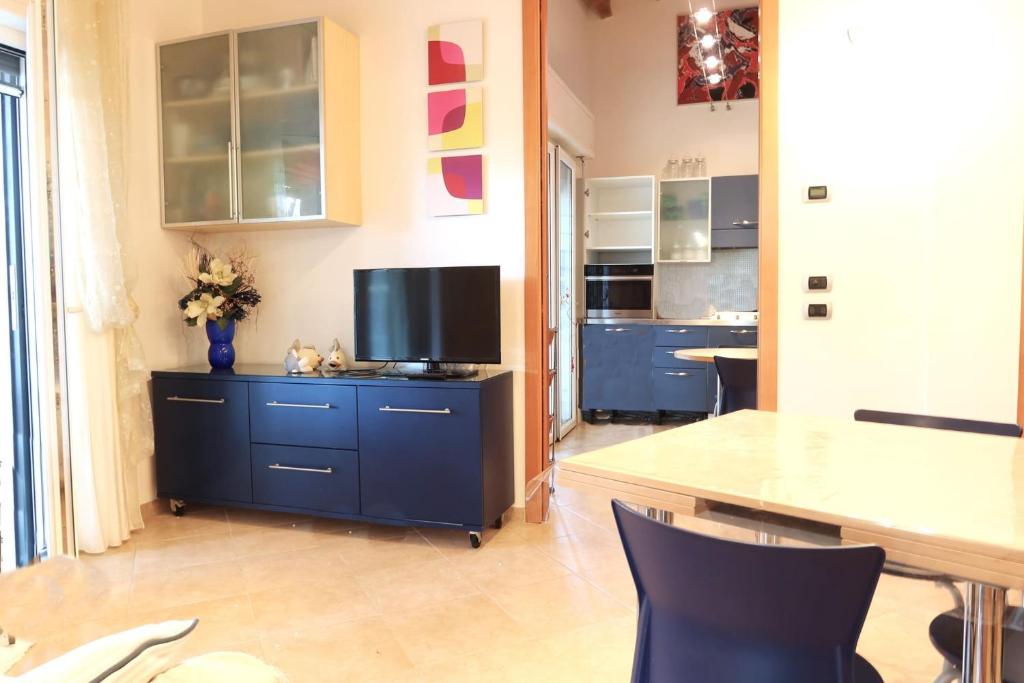 una cocina con un armario azul con TV. en MiMa mare e centro en Milano Marittima