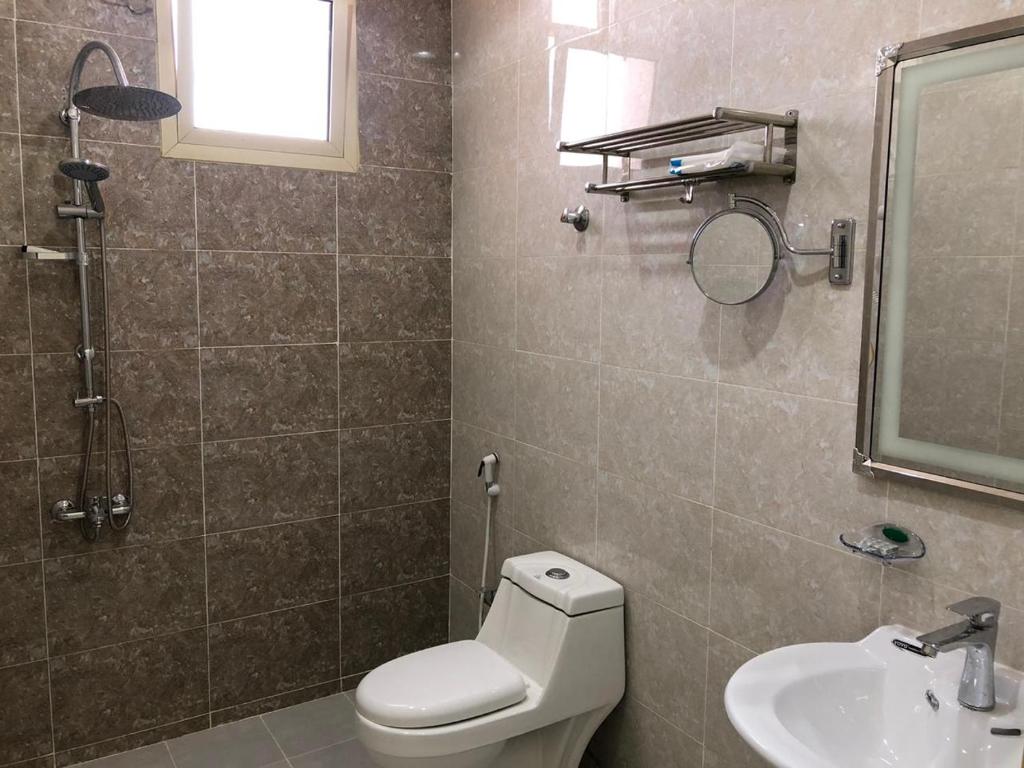 a bathroom with a toilet and a sink and a mirror at طيف للأجنحة الفندقية in Al Kharj