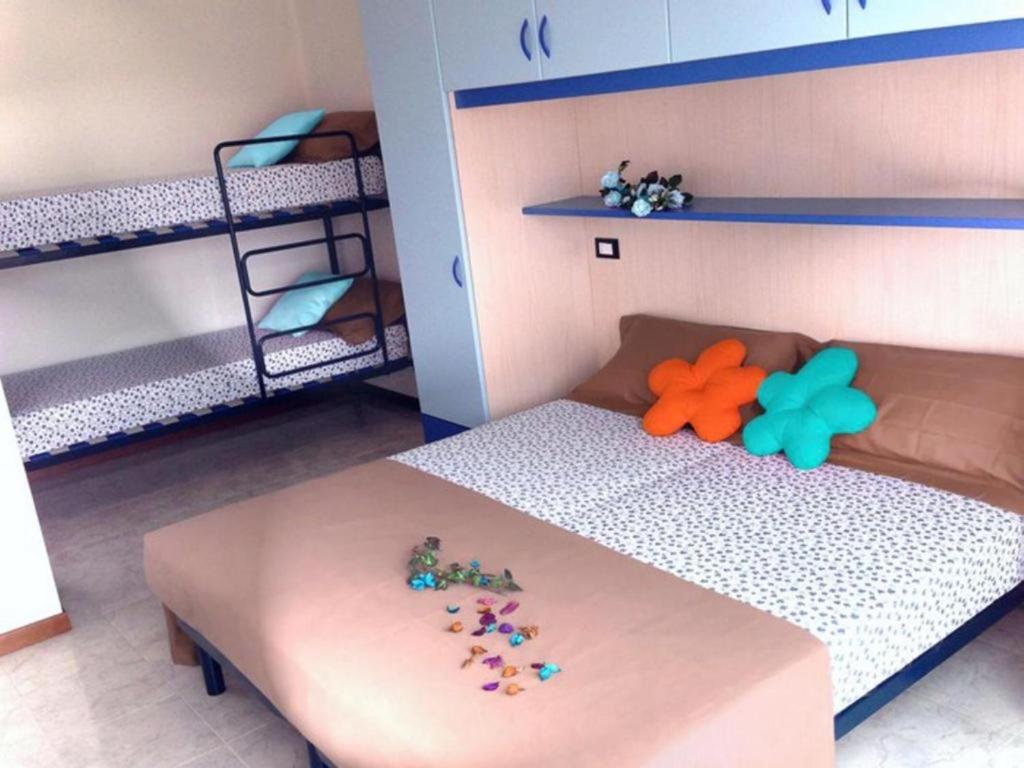ein Spielzeug-Schlafzimmer mit einem Bett und Etagenbetten in der Unterkunft Comfortable flat in a excellent location - Beahost in Bibione