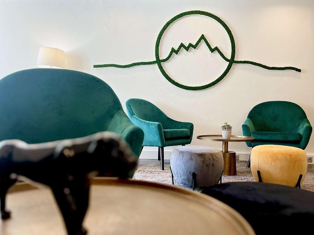 sala de estar con sillas verdes y mesa en Best Western Voiron Centre, en Voiron