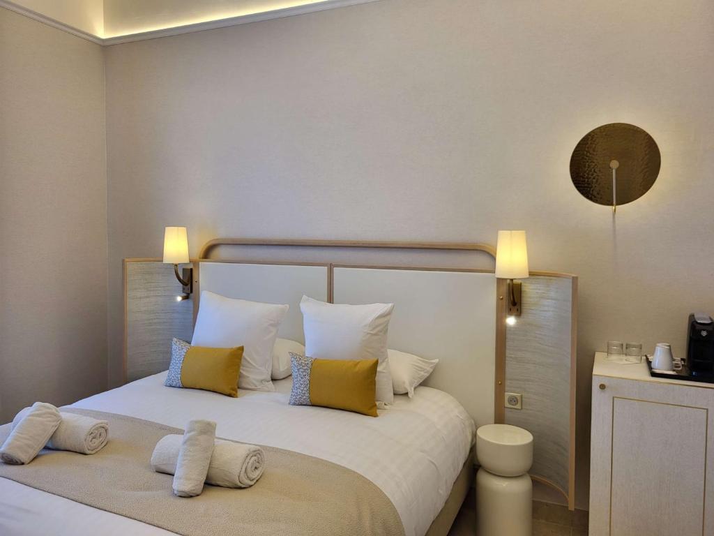 a bedroom with a large bed with yellow and white pillows at Grand Hotel Des Lecques; BW Signature Collection in Saint-Cyr-sur-Mer