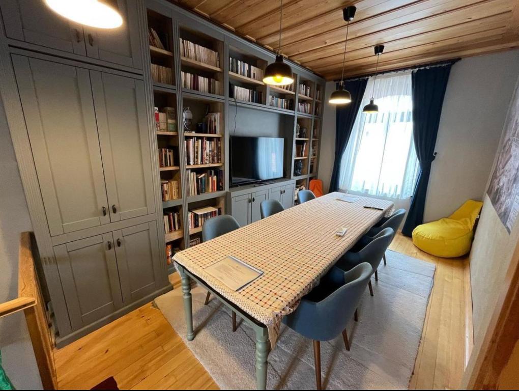 een eetkamer met een tafel en stoelen en boekenplanken bij Greek House with Terrace - Bachman Hause in Bergama