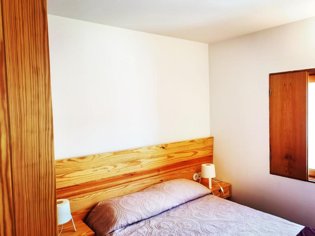 Un dormitorio con una cama con cabecero de madera. en Casa Do Pio Soajo, en Arcos de Valdevez