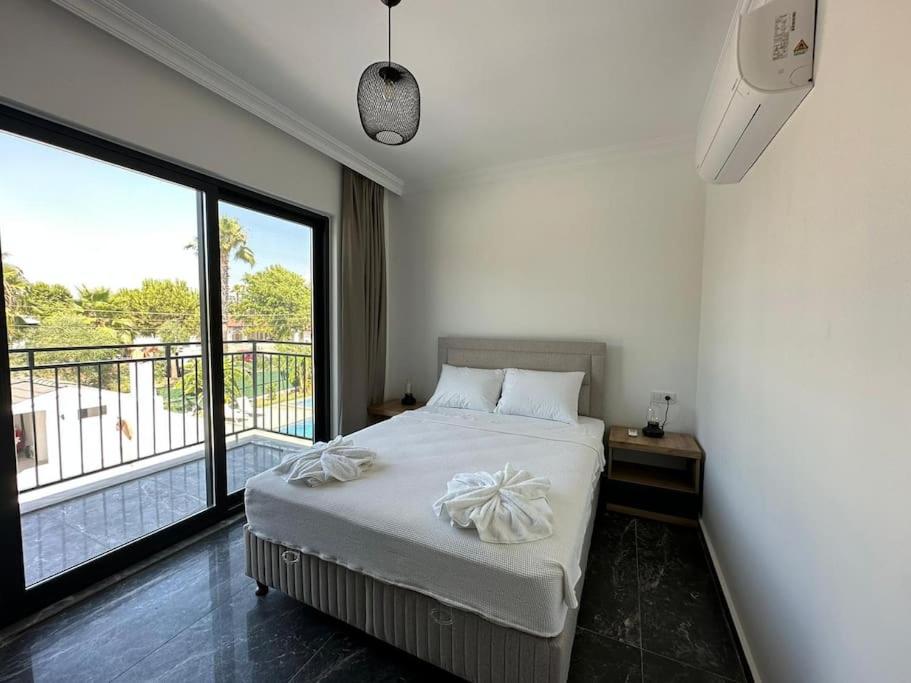 um quarto com uma cama e uma grande janela em Dalyan Villa Michael em Dalyan